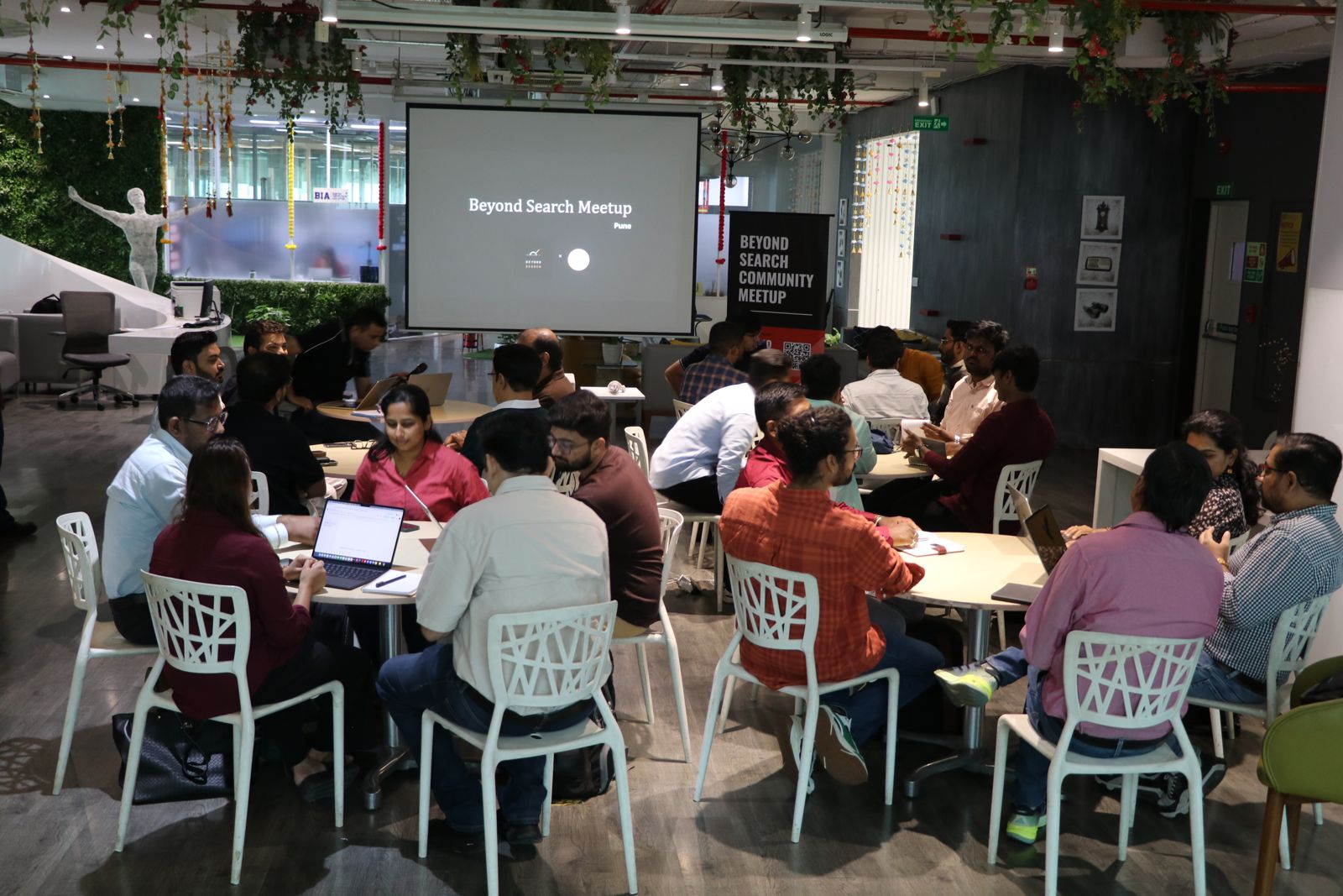 The full room at the Pune meetup, mastermind tables mid-session